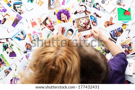 Mother with her kid looking on set of photos from amazing vacation