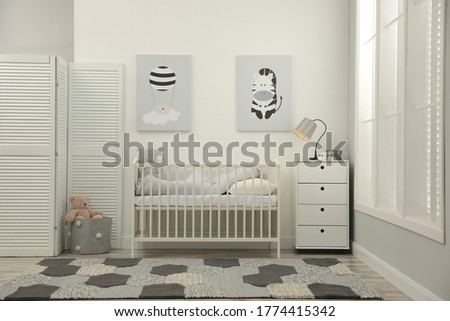 Stylish baby room interior with crib and chest of drawers