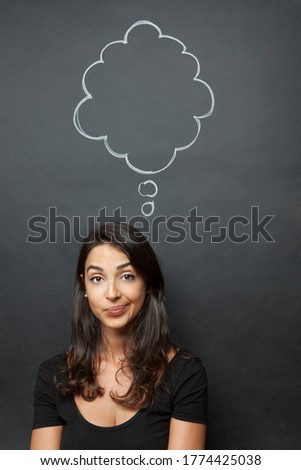 Dark-haired girl makes a funny face with a speech bubble drawn in the background that simulates thoughts