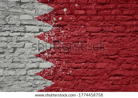 colorful painted big national flag of bahrain on a massive old brick wall