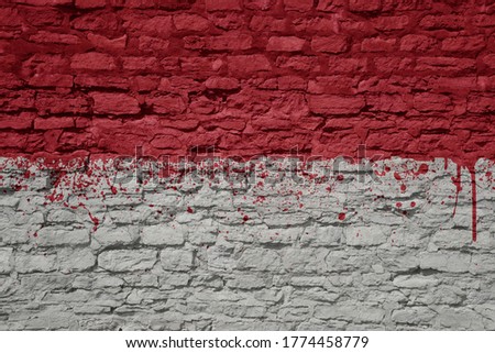 colorful painted big national flag of indonesia on a massive old brick wall