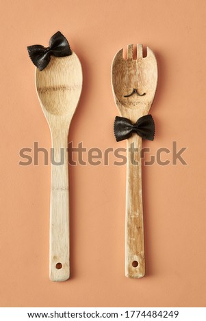 Cartoon girl and man made up of farfalle pasta and wooden spoon, conceptual photography for food blog or ad