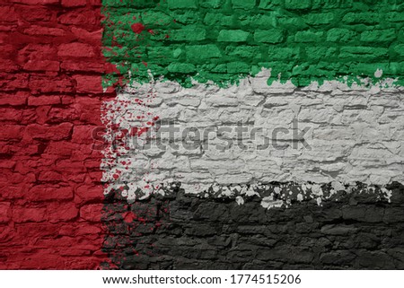 colorful painted big national flag of on a massive old brick wall