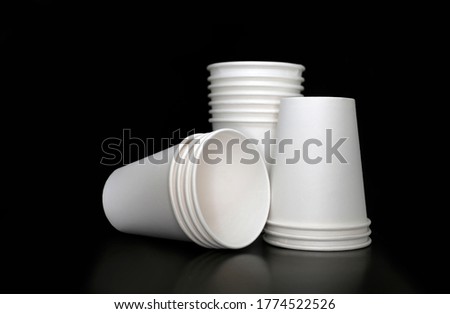 Three stacks of disposable white blank paper cups at black background, restaurant, cafe, drink delivery concept Royalty-Free Stock Photo #1774522526