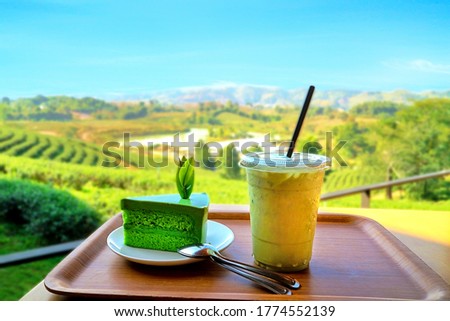 Delicious greentea dessert cake and drink with beautiful scenic view of green tea plantation terrace or field at Choui Fong, Chiang Rai, Thailand. Royalty-Free Stock Photo #1774552139