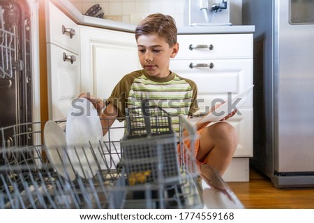 Little boy loading the dishwasher at home
 Royalty-Free Stock Photo #1774559168