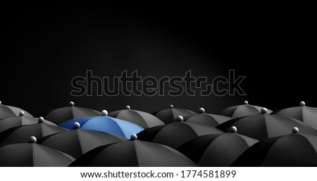 Concept image with lots of black umbrellas and a blue umbrella that stands out, be unique