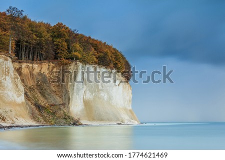 Chalk cliffs on the coast on the island of Rügen. Pirate bay in the morning in autumn at sunrise. Trees with foliage in the Jasmund National Park on the Baltic Sea