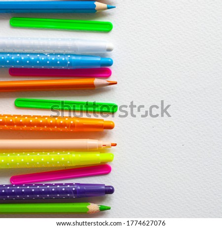 
background for text or greeting card, frame of colored pencils and felt-tip pens