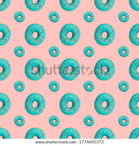 Donuts seamless pattern in blue glaze on a pink background.