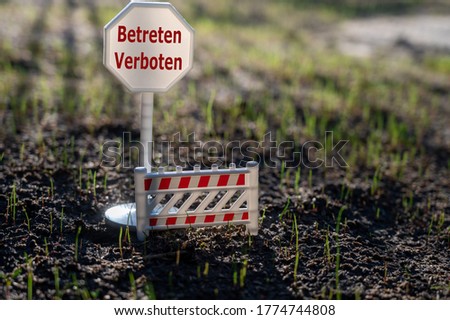 A sign with the German text "betreten verboten" (keep off) on a new lawn.