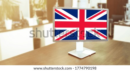 Monitor in modern office with united kingdom flag on the screen