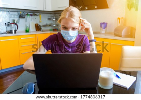 bright window light image for caucasian beautiful middle age woman working at home with laptop and notebook. writing note on the book with a pen like old style but use internet on the computer