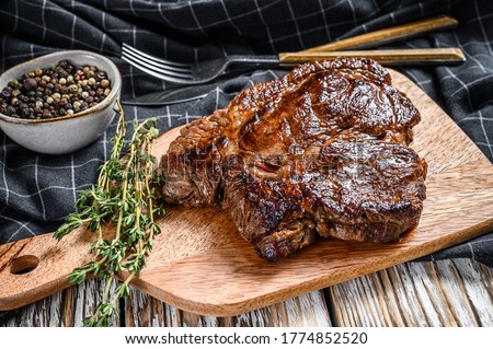 Cooked grilled Chuck eye roll steak on a chopping Board. White background. Top view Royalty-Free Stock Photo #1774852520