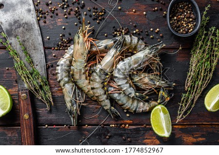 Fresh tiger shrimps, prawns with spices and herbs. Black woodenbackground. Top view Royalty-Free Stock Photo #1774852967
