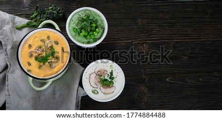 Vegetables cream soups on dark wooden background. Top view with copy space. Panorama, banner