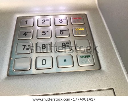 Photos of a close hand enters the PIN / password on the ATM / bank keypad.