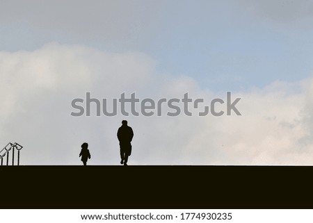 Man and his child silhouettes on the stairs