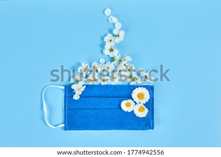 Medical protective mask and flowers in the shape of a coffee Cup. Concept of opening cafe after the pandemic covid-19.