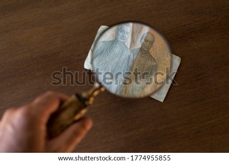 banknote augmented with old magnifying glass
