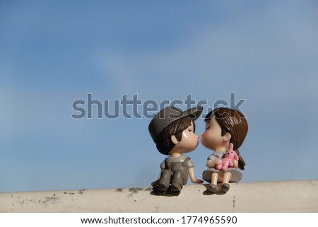 boy and girl doll sit and kiss each other