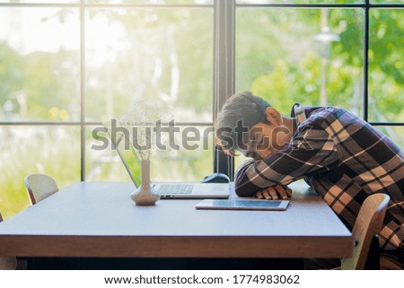 Early morning in the office or university. Tired young asian man sleeping next to his laptop computer. Copy space and Vintage color tone