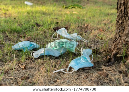 Facial surgical or medical masks used and thrown away on the garden. Problem of environmental pollution after pandemic. Royalty-Free Stock Photo #1774988708