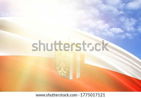 flag of Upper Austria against the blue sky with sun rays