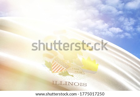 flag of State of Illinois against the blue sky with sun rays