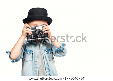Photographer kid taking a photo with vintage retro camera