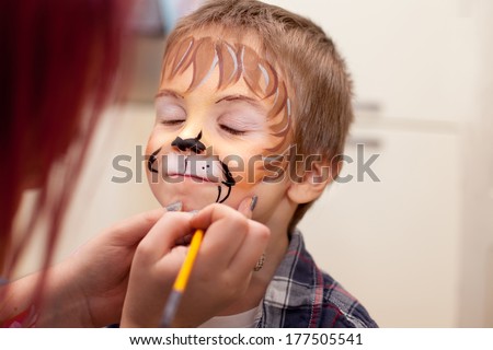 Little boy with painted face as a lion Royalty-Free Stock Photo #177505541