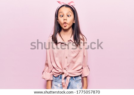 Beautiful child girl wearing casual clothes making fish face with lips, crazy and comical gesture. funny expression. 