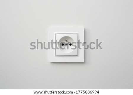 Brand new electrical socket isolated on gray wall. Renovated studio apartment power supply background. Empty copy space white plastic power outlet. Royalty-Free Stock Photo #1775086994