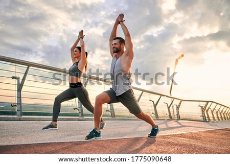 Couple doing sport together on the street. Yoga in the morning