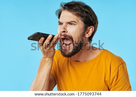  man with his mouth wide open holds a mobile phone in his hand