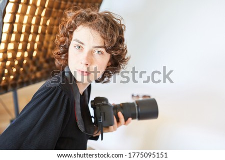 Professional photographer with SLR camera in the photo studio