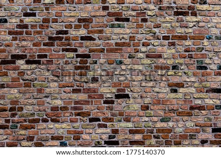 The wall of the Steintor in Rostock made of bricks with various large and colored stones.