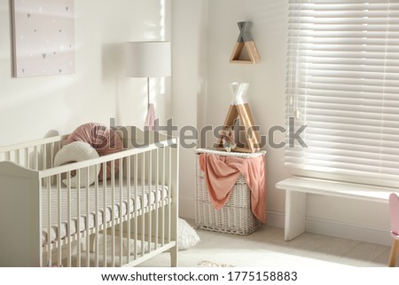Cute baby room interior with crib and decor elements
