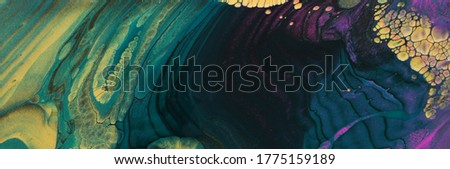 art photography of abstract marbleized effect background. Gold, purple, black and green creative colors. Beautiful paint.