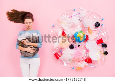 Top above high angle view upset eco activist girl hold rubbish bag look plastic cup glass plate disposal bottle surround globe dislike pollution flay lay isolated pastel color background