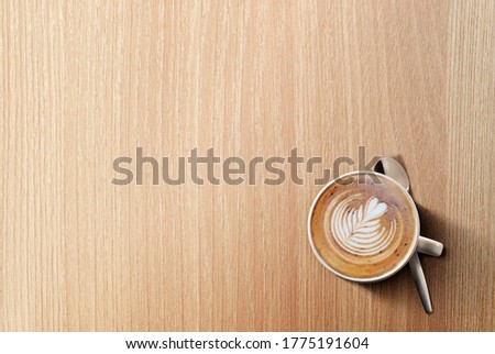 an aromatic cup of Cappuccino coffee on a wooden table
