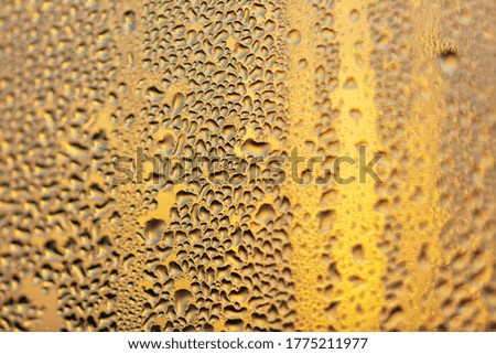 Drops of water on a glass window at dawn as an abstract background. Texture