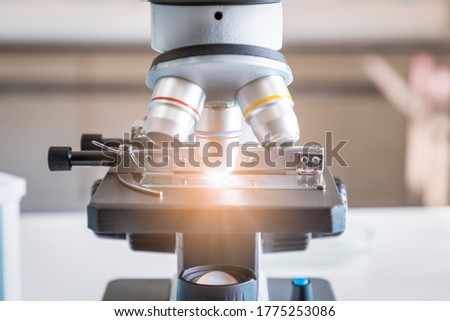 Close-up of microscope examining slide of sample. Concept for science and technology research in laboratory.