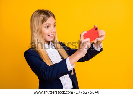 Close-up portrait of her she nice attractive addicted cheerful cheery long-haired girl using gadget playing game spending pause break isolated bright vivid shine vibrant yellow color background