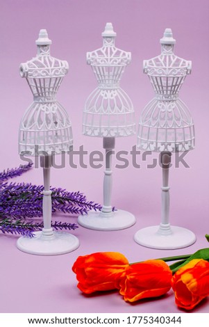 three white mannequins on a lilac background, lavender and three tulips