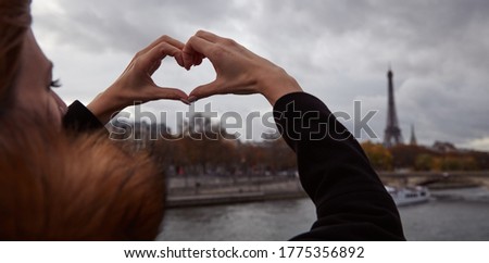 Girl using cellphone with Paris city background, Seine river and Eiffel tower.