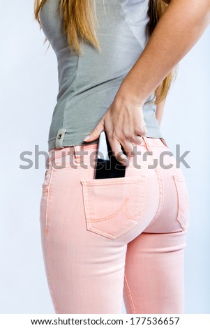 close-up portrait of Black smartphone in back pocket of girl's jeans