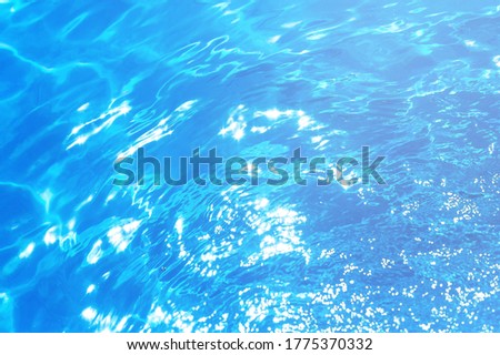 Sun patterns and splashes on the water in a swimming pool