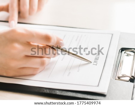 Girl sits at a table and signs a contract. Business. High quality photo