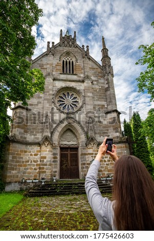 Beautiful girl with a phone on the background of the Gothic church. Tourism in Europe